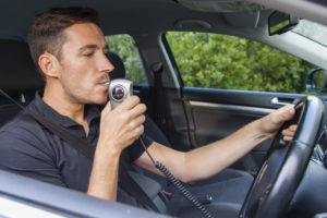 Man blowing into breathalyzer ignition interlock